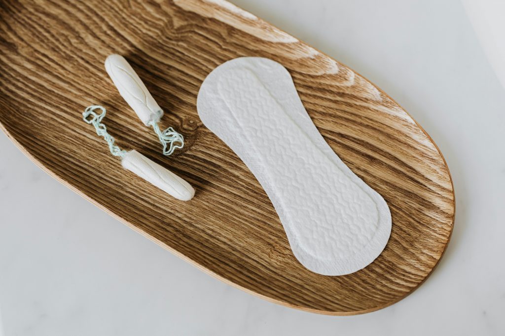 pexels-photo-4238993-4238993 Flat lay of tampons and pad on wooden tray illustrating feminine hygiene.