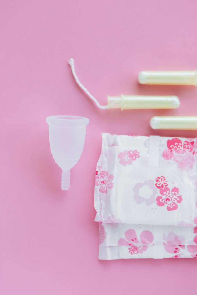 pexels-photo-5712318-5712318 Top view of menstrual cup, pads, and tampons on a pink background.