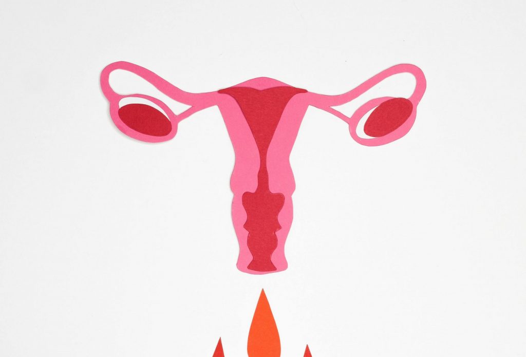 A bold illustration of a uterus with symbolic blood drops on a white background.