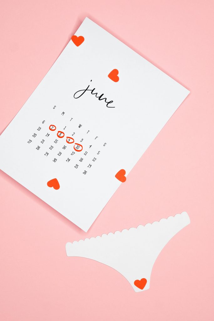 pexels-photo-7467101-7467101 Conceptual image of a June period calendar and paper panties, symbolizing menstruation awareness on a pink background.